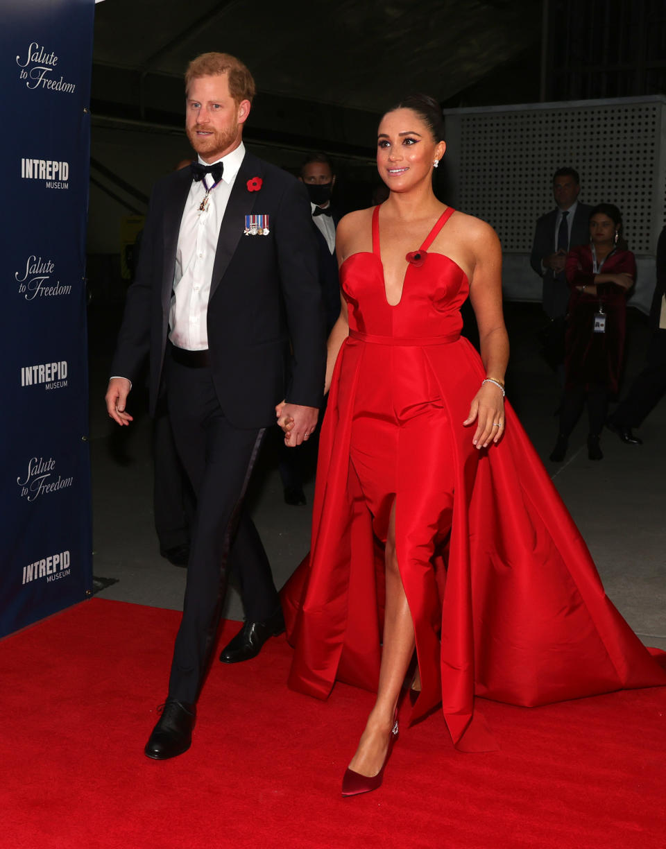 <p>Markle proved red's her colour in this fashion-forward, sleeveless gown - with a daring leg split - by Carolina Herrera. Matching satin Giuseppe Zanotti heels finished the look. (Getty Images)</p> 