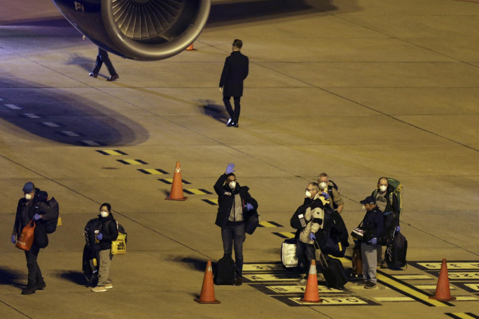 Passengers from the Australian cruise ship Greg Mortimer, get on a plane to be flown to Australia at the international airport in Montevideo, Uruguay, Saturday, April 11, 2020. Uruguay evacuated Australians and New Zealanders Friday from the cruise ship that has been anchored off the South American country coast since March 27 with more than half its passengers and crew infected with the new coronavirus. (AP Photo/Matilde Campodonico)