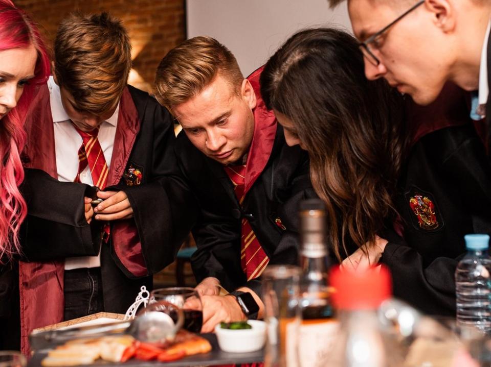 Leidenschaftliche Harry-Potter-Fans perfektionieren ihre Party mit ikonischen Gryffindor-Umhängen. (Bild: Ekaterina Soldatenko/Shutterstock.com)