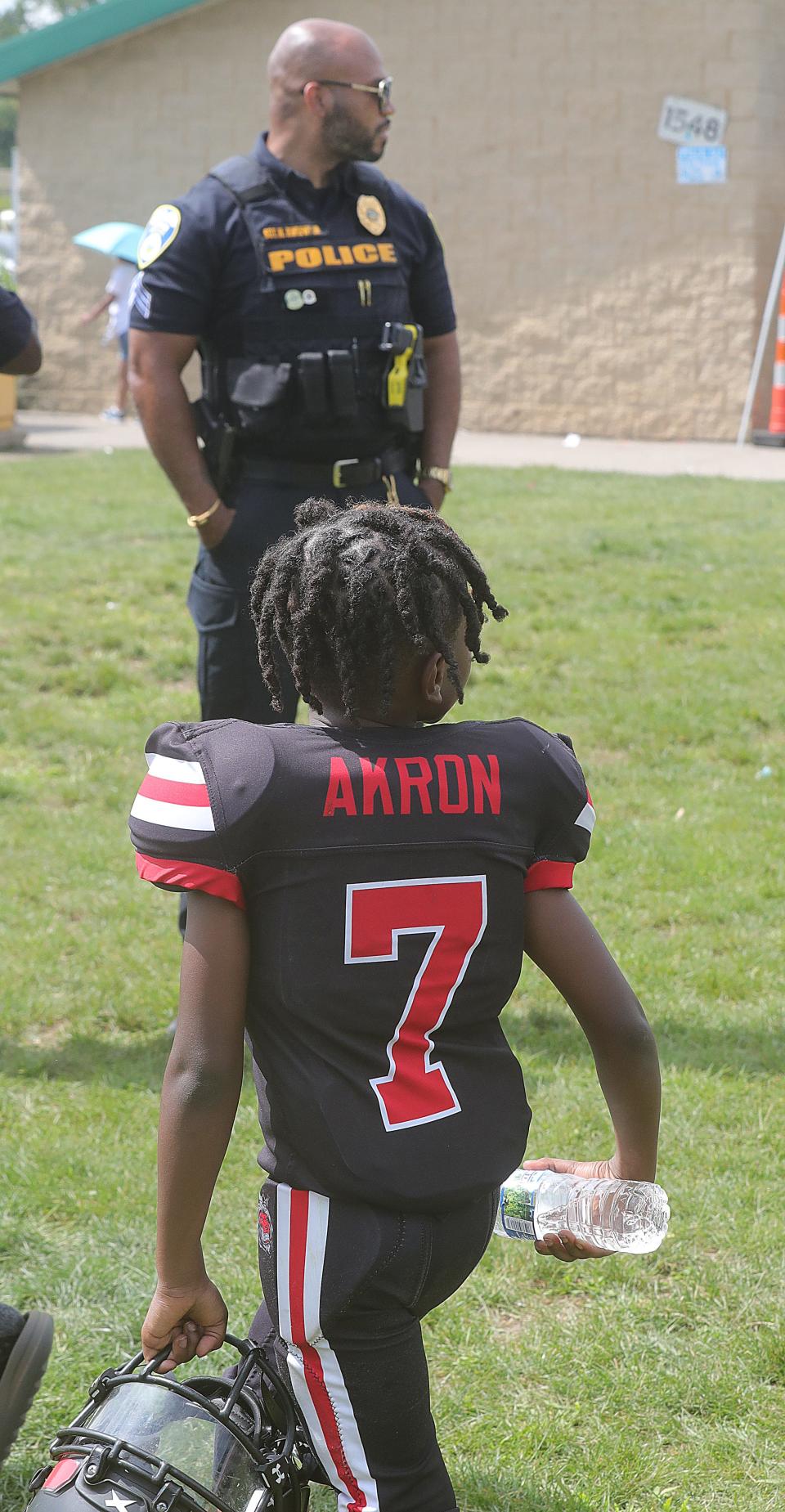 Akron Police Sgt. Mike Murphy Jr. keeps an eye on the pee wee football action Sunday at Erie Island Park.