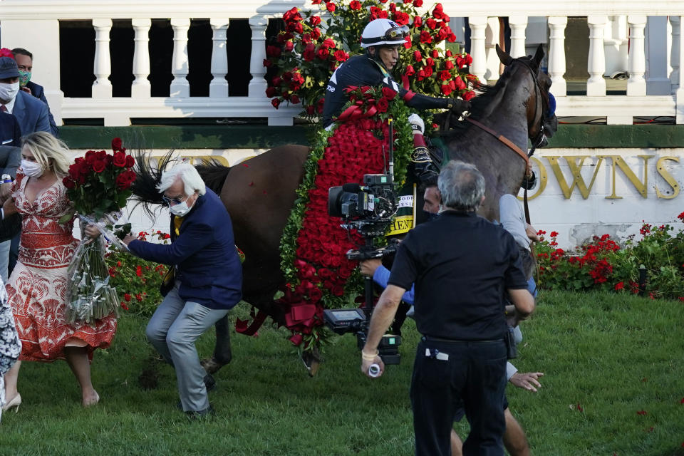 Trainer Bob Baffert is knocked to ground as jockey John Velazquez tries to control his horse Authentic in the winner's circle after winning the 146th running of the Kentucky Derby at Churchill Downs in Louisville, Ky., on Sept. 5, 2020. (AP Photo/Jeff Roberson)