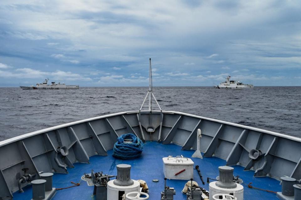 China Coast Guard ships (L and R) are seen from the Philippine Coast Guard vessel BRP Cabra during a supply mission to Sabina Shoal in disputed waters of the South China Sea on August 26, 2024. Sailors aboard two Philippine Coast Guard vessels crashed through South China Sea waves trying to bring food and other supplies to colleagues holed up inside a remote ring of reefs, as Chinese ships shadowed them. (Photo by JAM STA ROSA / AFP) (Photo by JAM STA ROSAJAM STA ROSA/AFP via Getty Images)