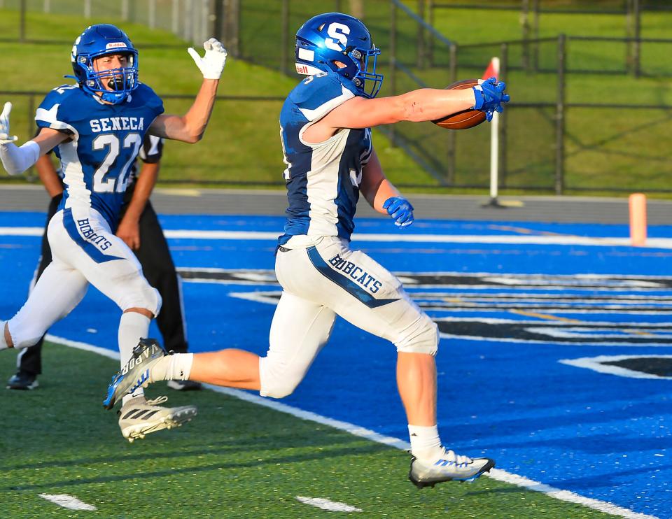 Seneca High School senior Beau Barber, left, celebrates a first-half touchdown by senior teammate Ryan Miller against Conneaut in Greene Township on Sept. 2, 2022.