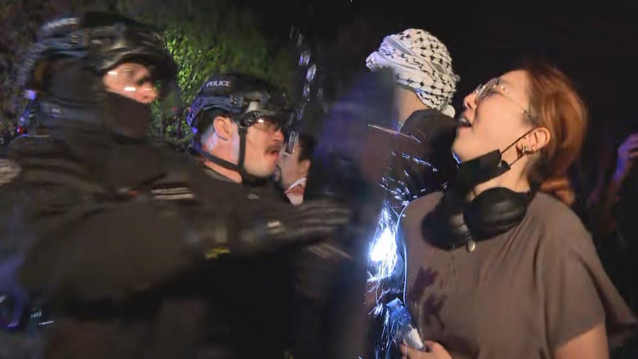 Calgary police officers and pro-Palestinian protesters clash during the forceful clearance of an encampment set up on the campus of the University of Calgary light Thursday night. (Jo Horwood/CBC - image credit)