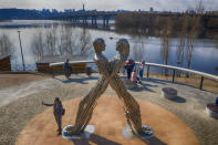 A woman takes a selfie near an art work in a city park as she enjoys a warm spring day in Kyiv, Ukraine, Tuesday, March 30, 2021. Ukraine has been under a three week coronavirus lockdown since March 20 as the country is struggling with a third wave of rising coronavirus infections. (AP Photo/Efrem lukatsky)