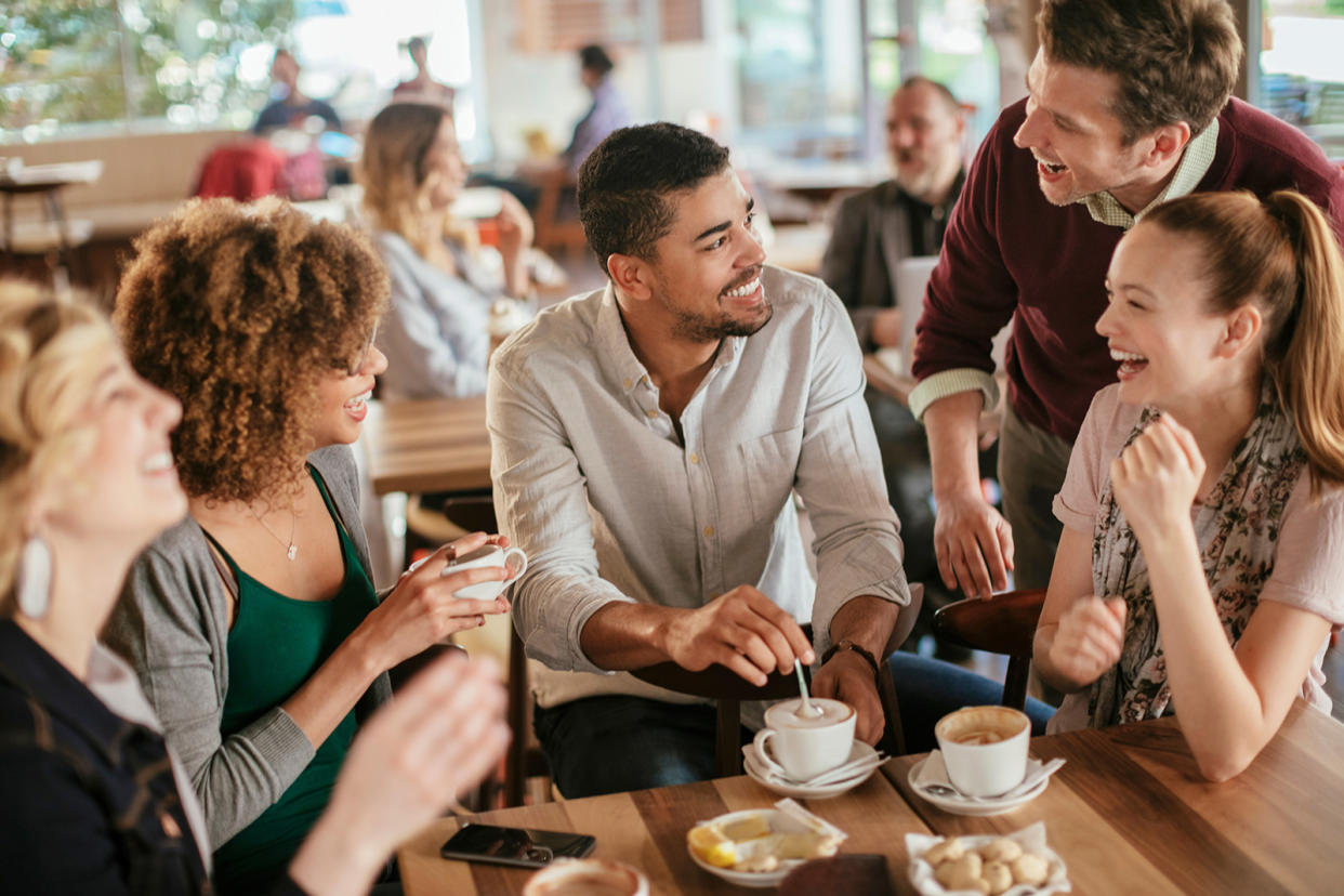 Group of young and diverse friends having coffee together in a cafe or bar