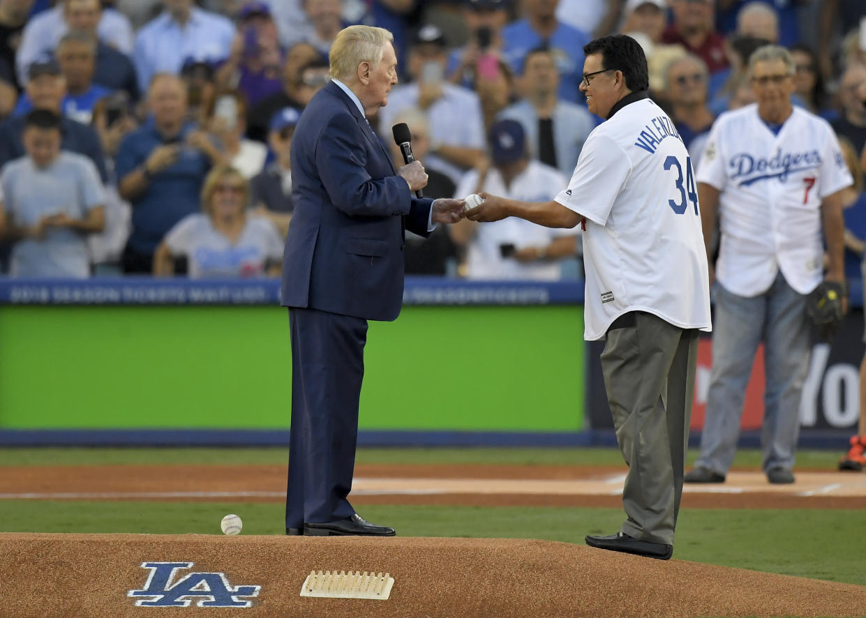 Fernando Valenzuela takes the first-ball from Vin Scully before Game 2 of the World Series at Dodger Stadium. (AP)