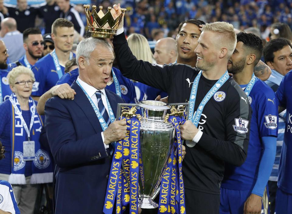 FILE - In this Saturday, May 7, 2016 file photo Leicester City team manager Claudio Ranieri has the crown of the trophy placed on his head by Leicester goalkeeper Kasper Schmeichel as they celebrate becoming the English Premier League soccer champions at King Power stadium in Leicester, England. Leicester City announced Thursday, Feb. 23, 2017 that they have sacked manager Claudio Ranieri less than a year after their incredible run to the Premier League title. (AP Photo/Matt Dunham, File)