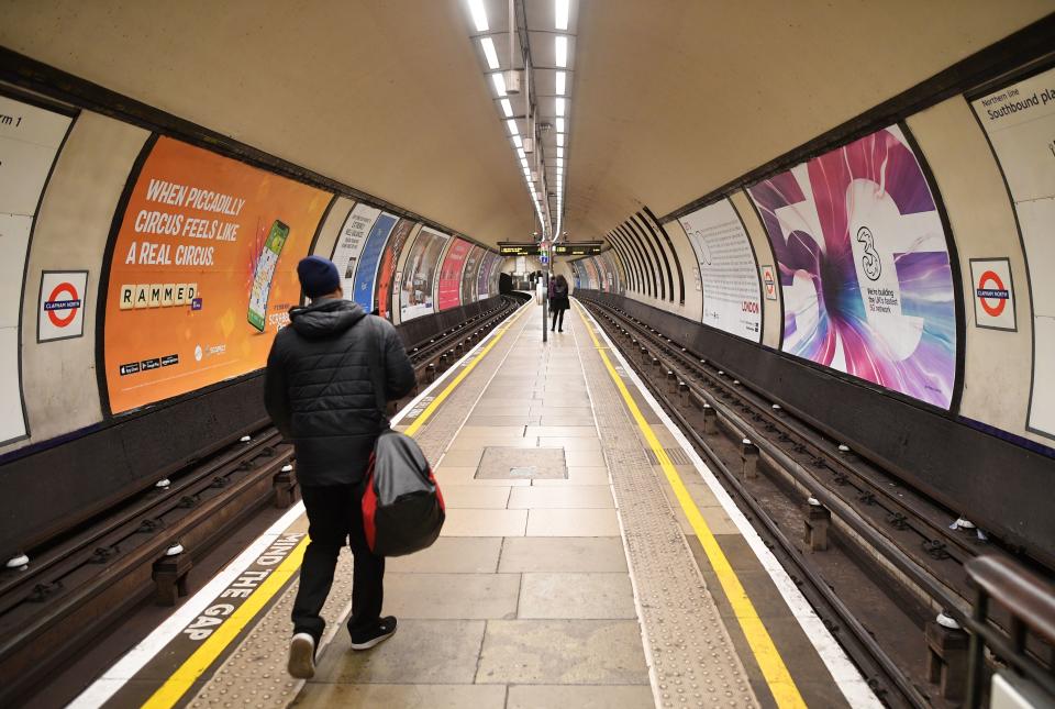 TOPSHOT - Few commuters wait on the platform for the metro train during the rush hour time of 0800 at Clapham Common, London on March 17, 2020. - Britain stepped up its response to coronavirus, recommending household isolation, home-working and an end to mass gatherings to try to stem an accelerating outbreak. (Photo by JUSTIN TALLIS / AFP) (Photo by JUSTIN TALLIS/AFP via Getty Images)