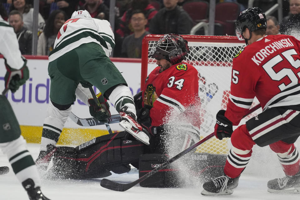 Minnesota Wild left wing Marcus Foligno, left, crashes into Chicago Blackhawks goaltender Petr Mrazek, drawing a goalie interference penalty during the first period of an NHL hockey game, Wednesday, Feb. 7, 2024, in Chicago. (AP Photo/Erin Hooley)