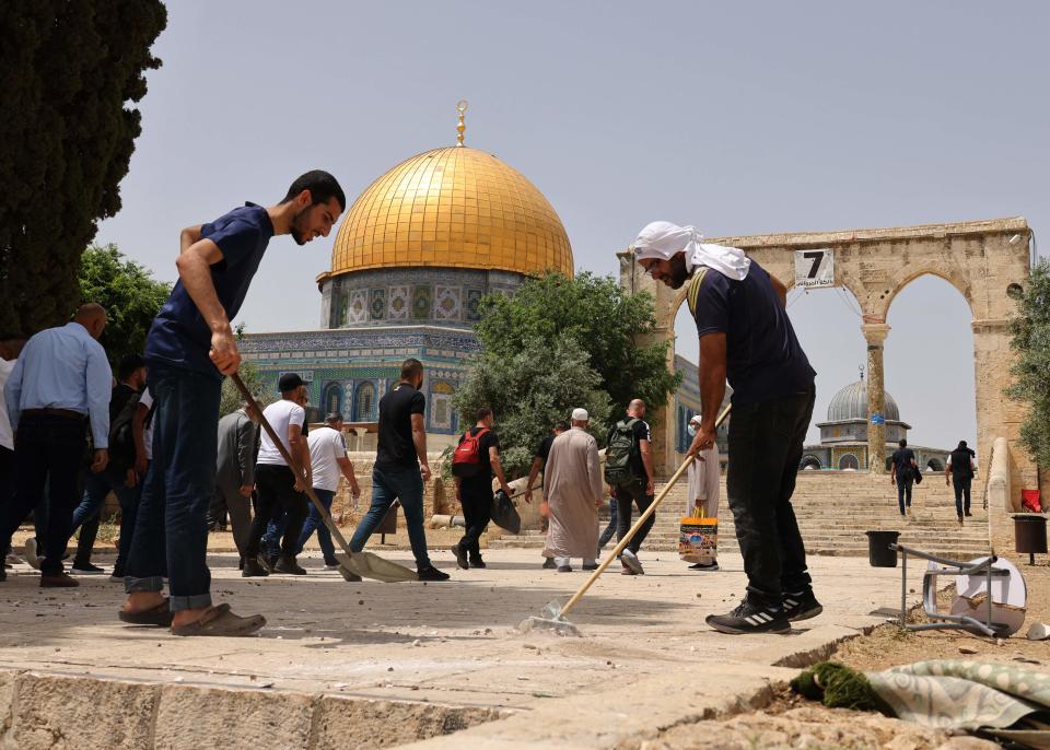 Palestinians clean the Al-Aqsa mosque compound on May 10, 2021, following renewed violence with Israeli police.