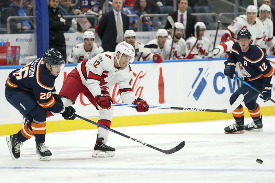 Carolina Hurricanes center Jesperi Kotkaniemi (82) skates against New York Islanders right wing Oliver Wahlstrom (26) during the first period of an NHL hockey game Saturday, Dec. 10, 2022, in Elmont, N.Y. (AP Photo/Mary Altaffer)