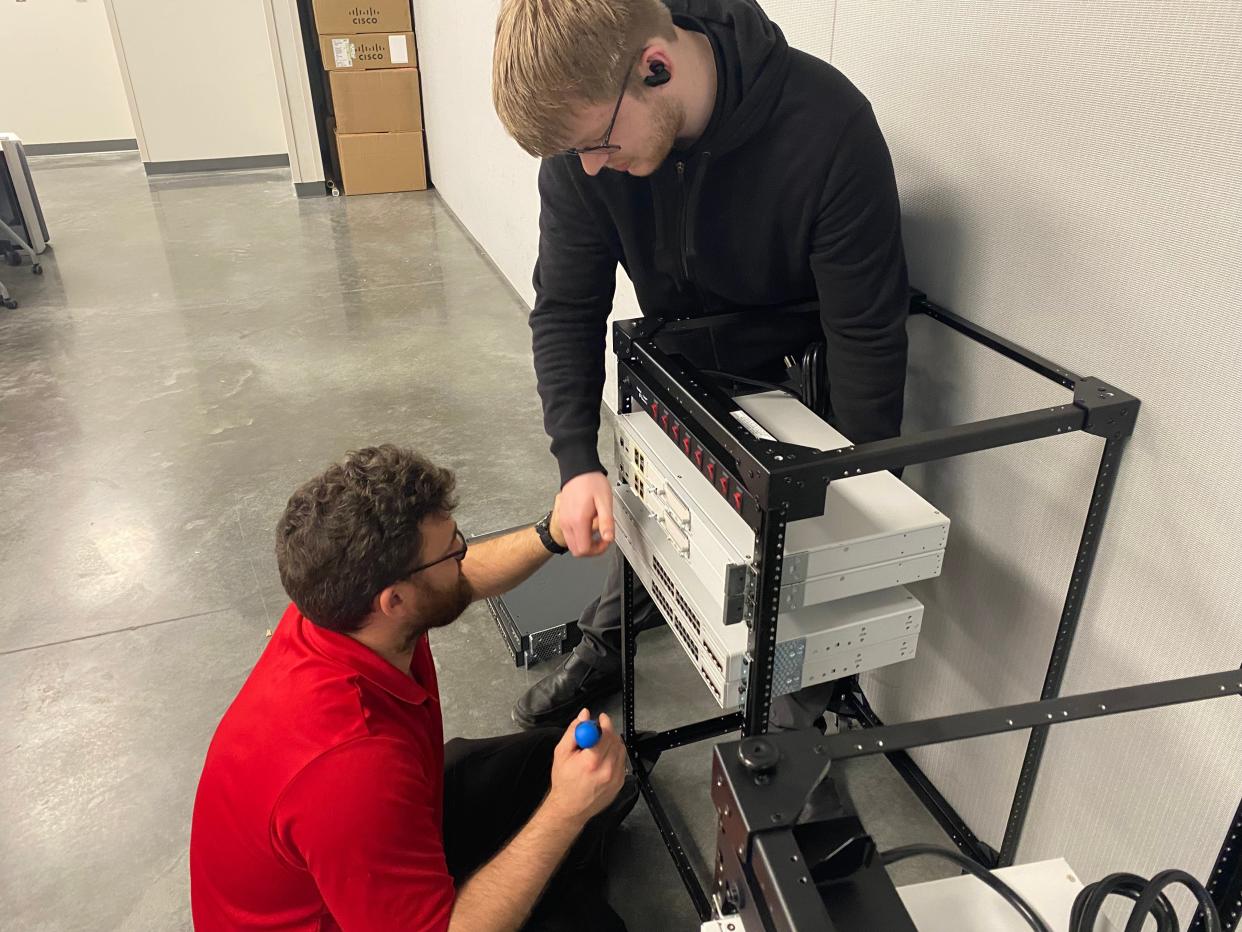 Ranken Technical College information technology students Jonathan Frangenberger, in red, and Curt Lynn on Friday install networking equipment on a rack to be used as the school's server. Ranken Technical College held a ribbon-cutting ceremony of its new location in Ashland