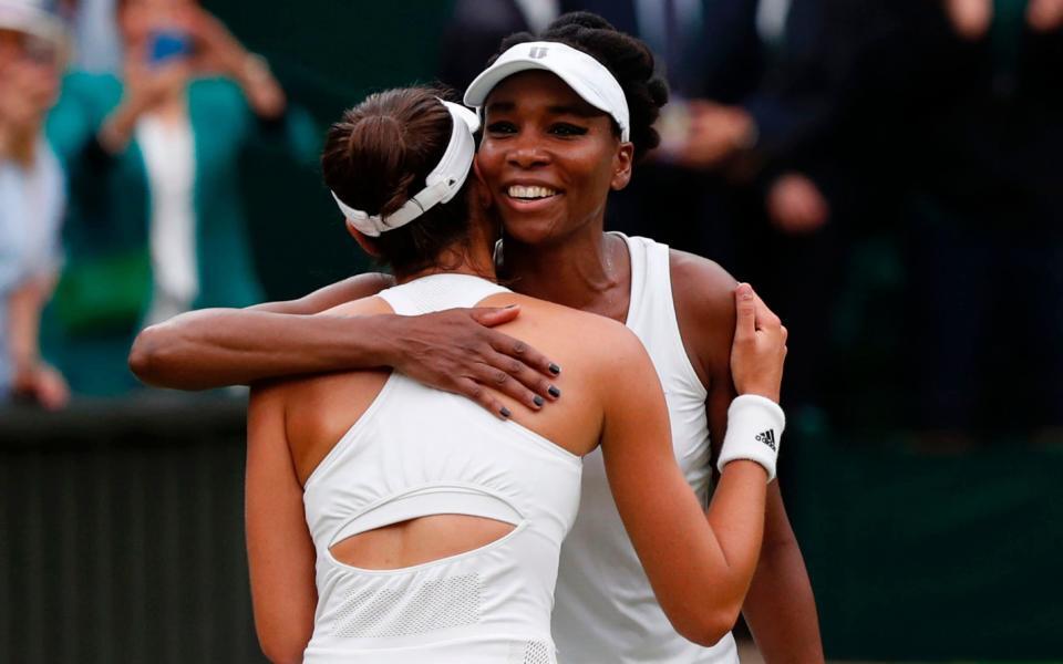 Spain's Garbine Muguruza (L) hugs US player Venus Williams after winning their women's singles final match