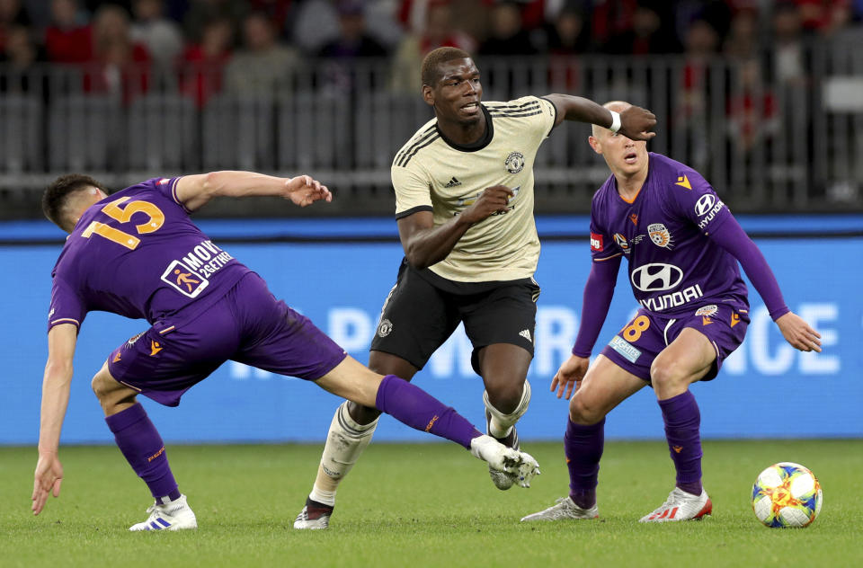 Manchester United's Paul Pogba, centre, challenges for the ball with unidentified Perth Glory players, during their friendly soccer match in Perth, Australia, Saturday, July 13, 2019. (Richard Wainwright/AAP Image via AP)