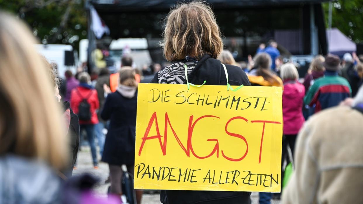 Angst sei die schlimmste Pandemie aller Zeiten, meint dieser Demonstrant bei einem Gottesdienst am Ufer des Bodensees.