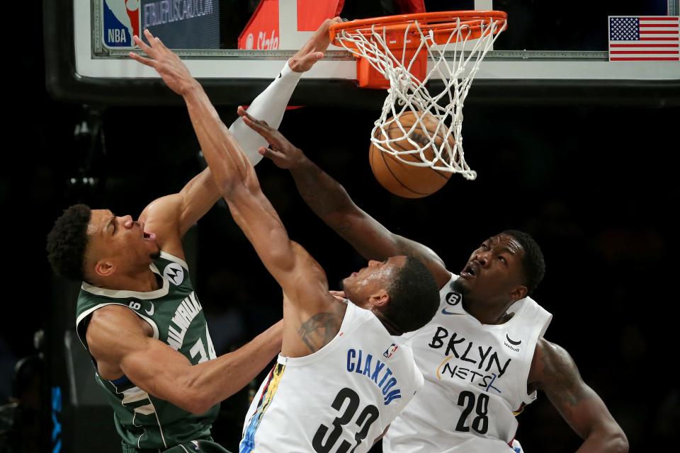 Bucks forward Giannis Antetokounmpo throws down a unk against Nets center Nic Claxton (33) and forward Dorian Finney-Smith during the first quarter Tuesday night.