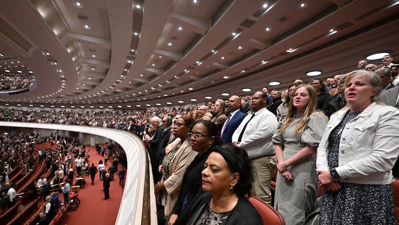 Crowd members stand and join with the Tabernacle Choir during a song at the Conference Center for General Conference in Salt Lake City on Saturday, April 6, 2024.