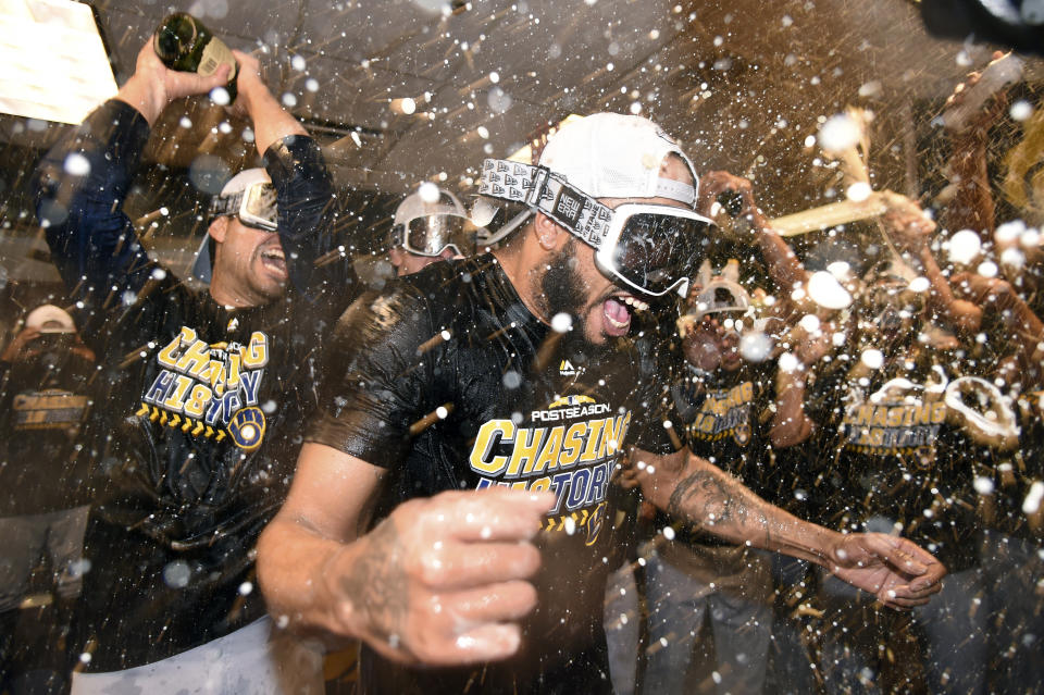 Milwaukee Brewers relief pitcher Jeremy Jeffress is doused by teammates as they celebrate in the clubhouse after Game 3 of a baseball National League Division Series against the Colorado Rockies, Sunday, Oct. 7, 2018, in Denver. The Brewers swept the series in three games and move on to the National League Championship Series. (AP Photo/John Leyba)