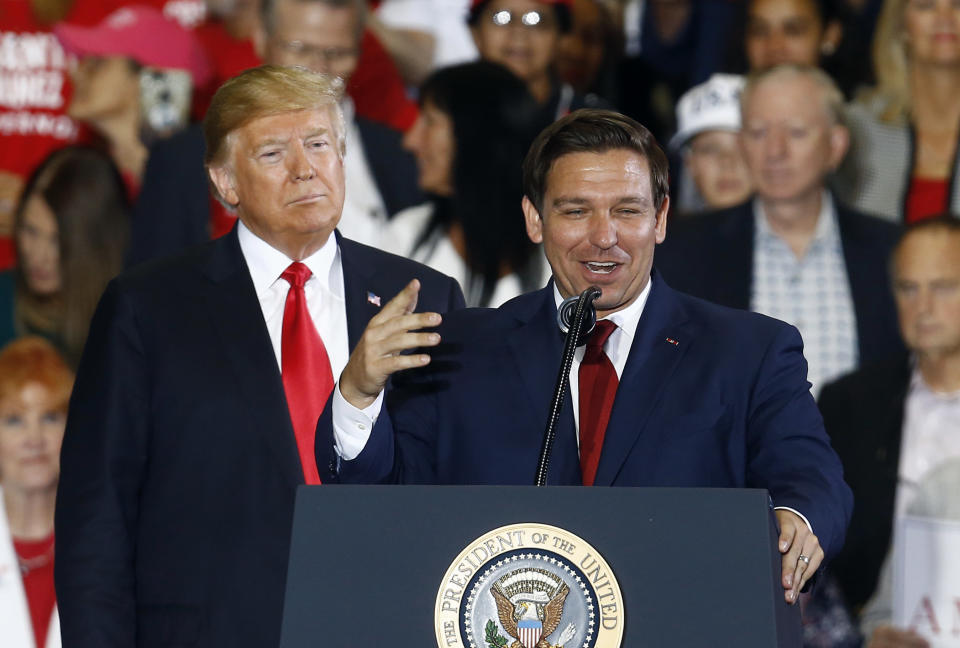 FILE- In this Nov. 3, 2018 file photo President Donald Trump stands behind gubernatorial candidate Ron DeSantis at a rally in Pensacola, Fla. (AP Photo/Butch Dill, File)