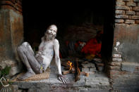 <p>A Hindu holy man, or sadhu, sits beside a fire after smearing his body with ashes at the premises of Pashupatinath Temple, ahead of the Maha Shivaratri festival in Kathmandu, Nepal, Feb. 21, 2017. REUTERS/Navesh Chitrakar </p>