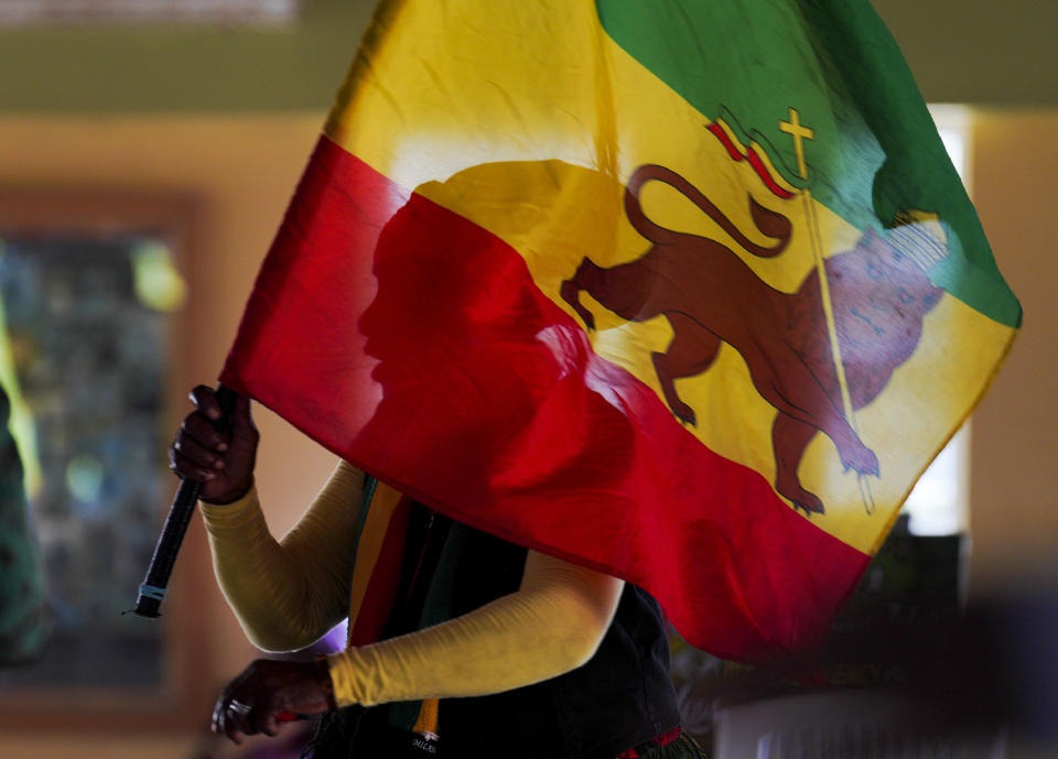 Francis, a Rastafari member, waves a Rastafari flag during service in the tabernacle on Sunday, May 14, 2023, on the Ras Freeman Foundation for the Unification of Rastafari property in Liberta, Antigua. (AP Photo/Jessie Wardarski)