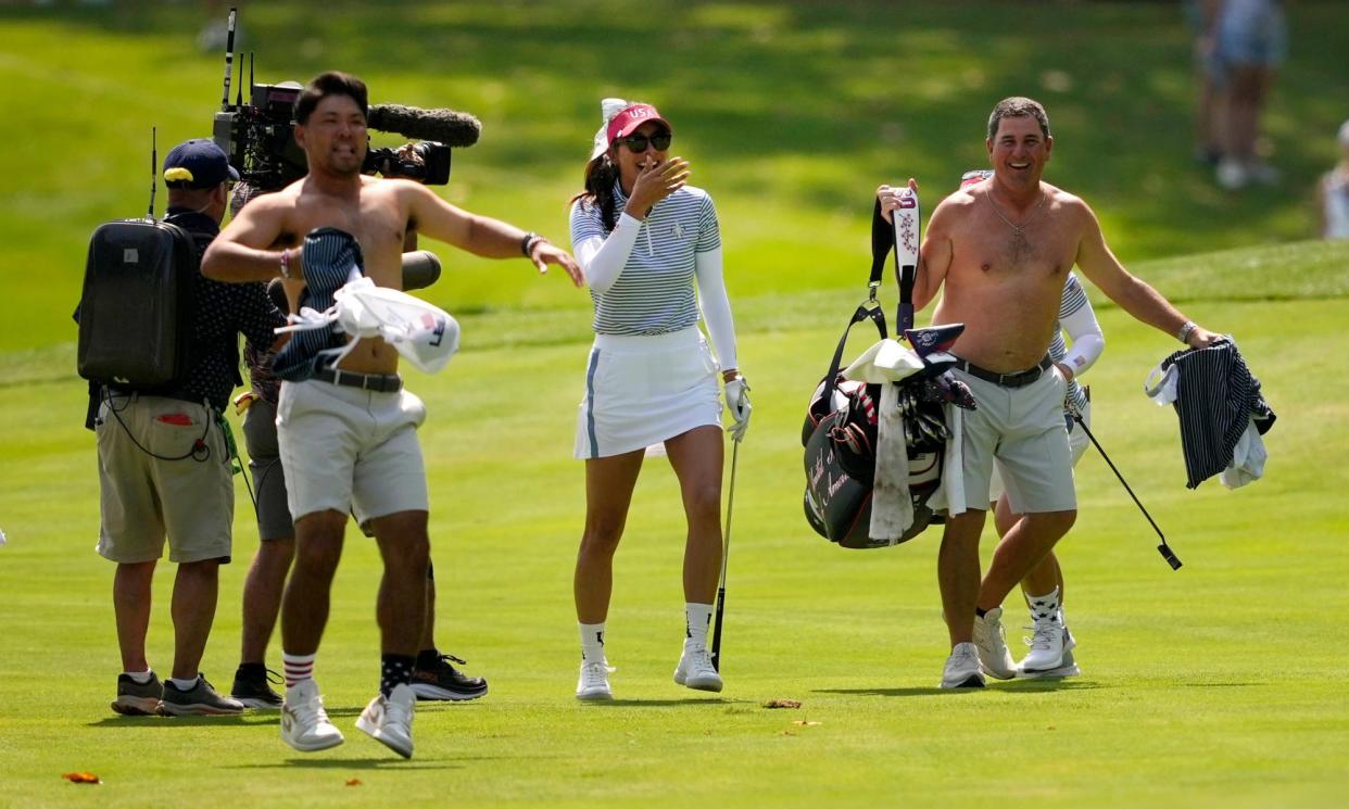 <span>USA caddies remove their shirts to celebrate Alison Lee holing out from a fairway.</span><span>Photograph: Matt York/AP</span>