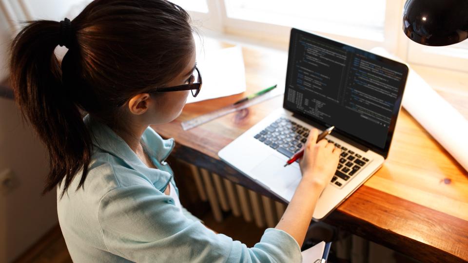 Young female programmer working at home.