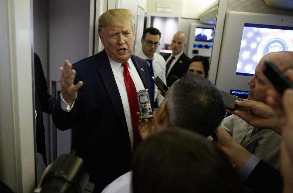 President Donald Trump talks to reporters aboard Air Force One after visiting Dayton, Ohio and El Paso, Texas, Wednesday, Aug. 7, 2019. (AP Photo/Evan Vucci)