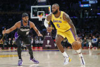 Los Angeles Lakers forward LeBron James (6) drives past Sacramento Kings forward Maurice Harkless (8) during the first half of an NBA basketball game in Los Angeles, Friday, Nov. 26, 2021. (AP Photo/Ringo H.W. Chiu)