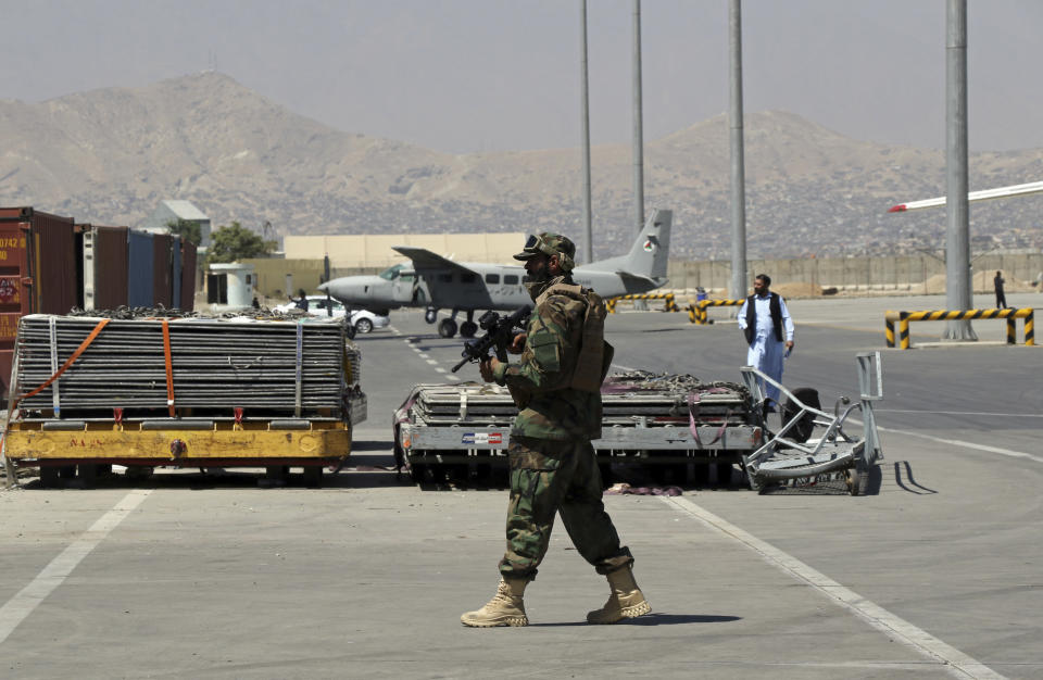 A Taliban soldier walks on the tarmac at Hamid Karzai International Airport in Kabul, Afghanistan, Sunday, Sept. 5, 2021. Some domestic flights have resumed at Kabul's airport, with the state-run Ariana Afghan Airline operating flights to three provinces. (AP Photo/Wali Sabawoon)