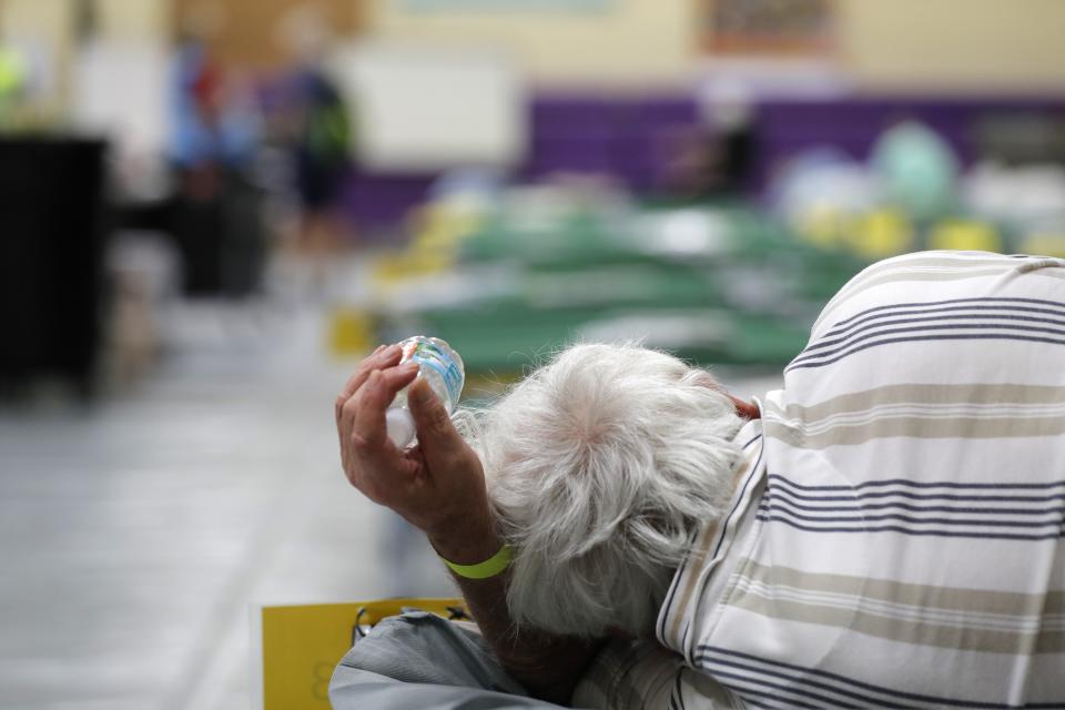 FILE - In this Sept. 1, 2019, file photo, an evacuee lies on a cot at an evacuation shelter for people with special needs, in preparation for Hurricane Dorian, at Dr. David L. Anderson Middle School in Stuart, Fla. Local officials across the South are still scurrying to fix their hurricane evacuation and sheltering plans because of changes needed due to coronavirus and a cratering economy. (AP Photo/Gerald Herbert, File)