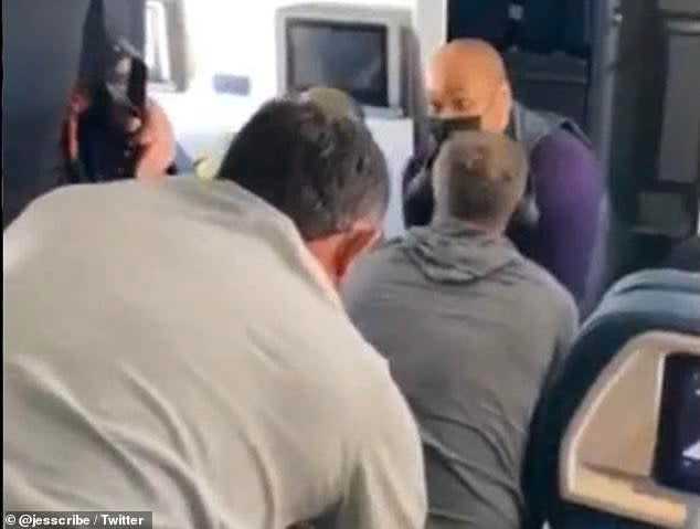 A video posted on Twitter by a passenger on a flight to Nashville shows attendants and passengers holding down a man who reportedly attempted to break into the cockpit (Twitter/Jessica Robertson)