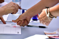 <p>A Venezuelan resident in Madrid stamps fingerprint at a polling station during a symbolic plebiscite on president Maduro’s project of a future constituent assembly, called by the Venezuelan opposition and held at the Puerta del Sol in Madrid on July 16, 2017. (Gerard Julien/AFP/Getty Images) </p>