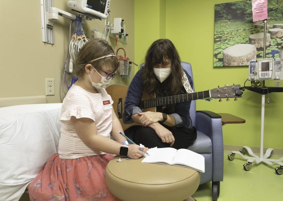 Folk singer Kristen Graves and 7-year-old Ivy write songs together during Ivy's follow-up visit in September to the HSHS St. Vincent Children’s Hospital pediatric hematology and oncology clinic.