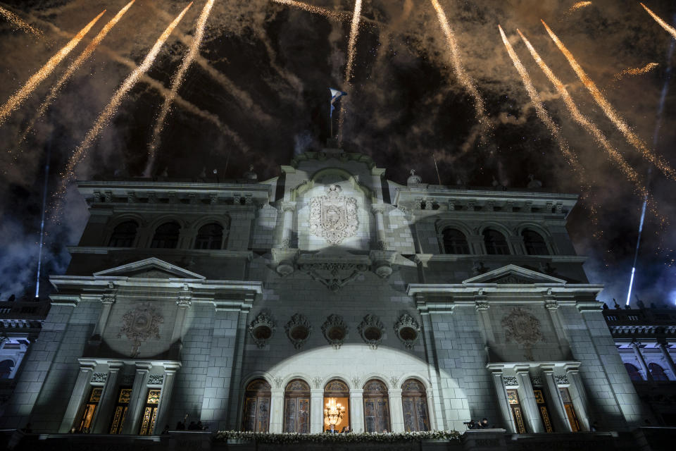 Fireworks explode over the National Palace as incoming Guatemalan President Bernardo Arévalo and Vice President Karin Herrera wave to supporters from the balcony on their inauguration day in Guatemala City, early Monday, Jan. 15, 2024. (AP Photo/Santiago Billy)