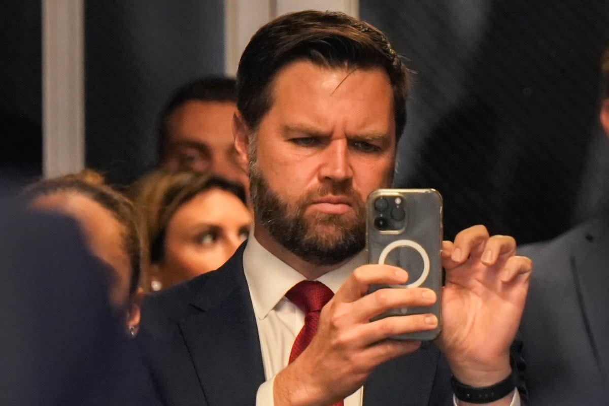 Republican vice presidential candidate J.D. Vance looks at his phone as former U.S. President Donald Trump speaks to the media with attorney Todd Blanche as he arrives for court during his trial for allegedly covering up hush money payments at Manhattan Criminal Court on May 13, 2024 in New York City.  (Getty Images)