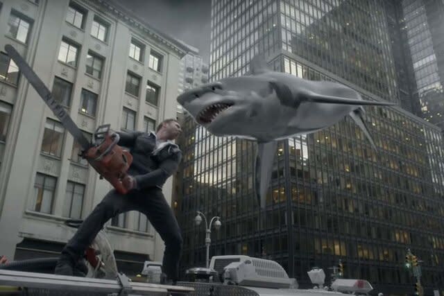 A man with a chainsaw attacks a flying shark.