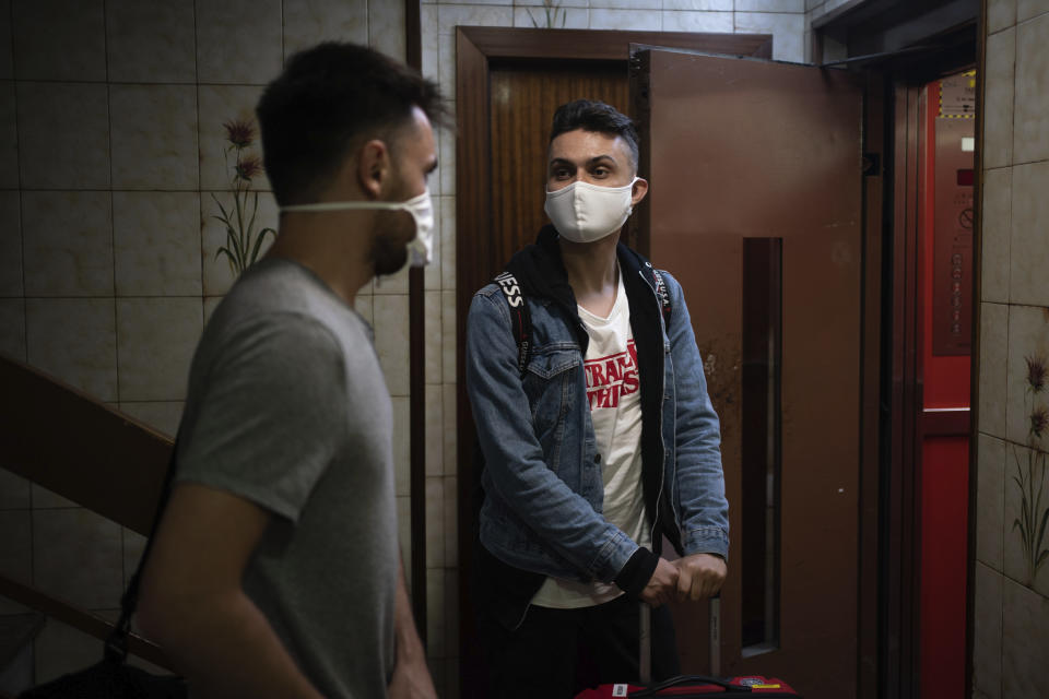 Piotr Grabarczyk, right, and his boyfriend Kamil Pawlik, from Poland, enter the elevator as they arrive in their temporary apartment in Barcelona, Spain, early Wednesday, July 29, 2020. Like them, many LGBT people are choosing to leave Poland amid rising homophobia promoted by President Andrzej Duda and other right-wing populist politicians in power. (AP Photo/Felipe Dana)