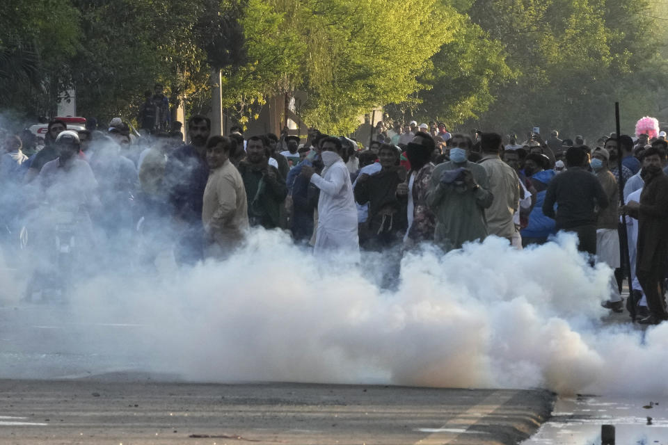 Supporters of Pakistan's former Prime Minister Imran Khan run for cover as police fire tear gas shells to disperse them during clashes, in Lahore, Pakistan, Wednesday, March 8, 2023. Pakistani police used water cannons and fired tear gas to disperse supporters of the country's former Prime Minister Khan Wednesday in the eastern city of Lahore. Two dozen Khan supporters were arrested for defying a government ban on holding rallies, police said. (AP Photo/K.M. Chaudary)