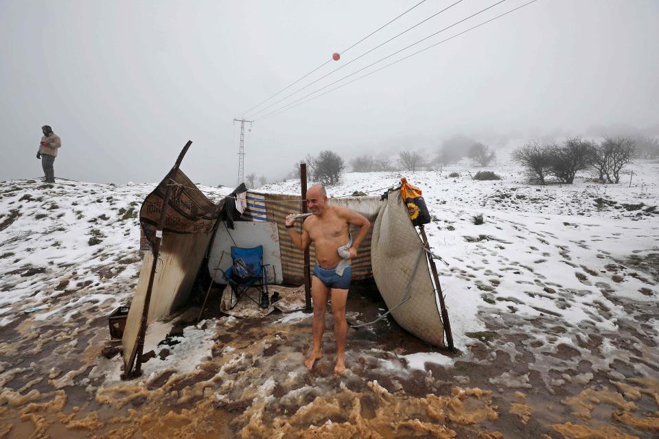 An Israeli man dries himself after swimming in a hot spring following a snow storm near Merom Golan Kibbutz in the Israel-annexed Golan Heights, on January 19, 2022.