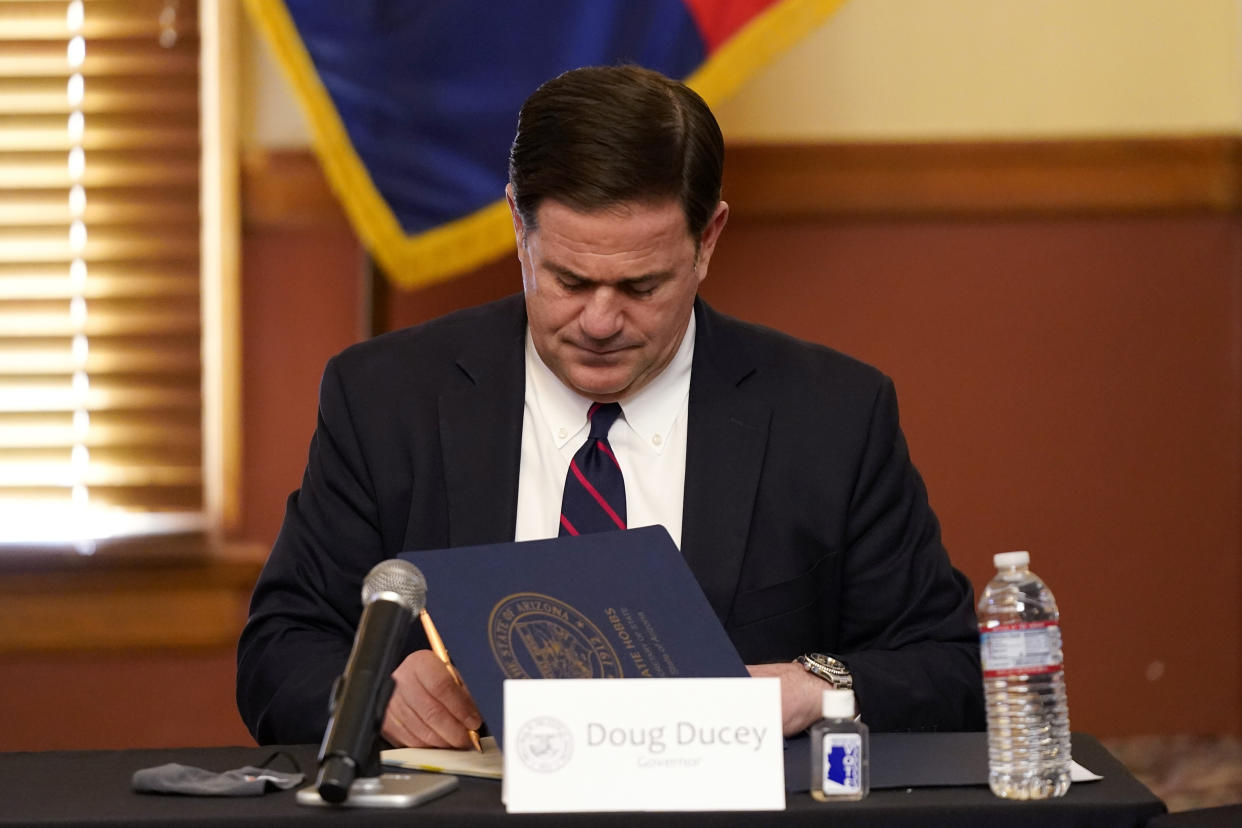 Arizona Gov. Doug Ducey signs election documents to certify the election results for federal, statewide, and legislative offices and statewide ballot measures at the official canvass at the Arizona Capitol in Phoenix on Nov. 30, 2020. (Ross D. Franklin/Pool via AP)