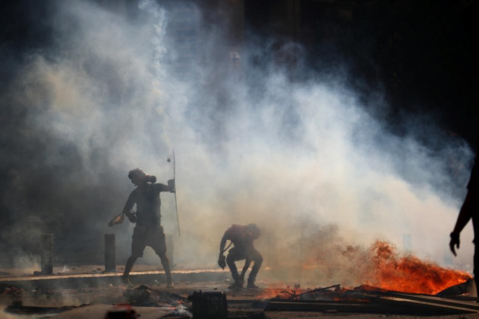 A demonstrator holds a shield during a protest (REUTERS)