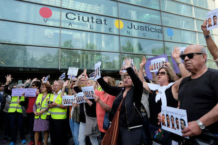 People shout slogans while holding signs during a protest outside the City of Justice, after a Spanish court on Thursday sentenced five men accused of the group rape of an 18-year-old woman at the 2016 San Fermin bull-running festival each to nine years in prison for the lesser charge of sexual abuse, in Valencia, Spain April 27, 2018. REUTERS/Heino Kalis