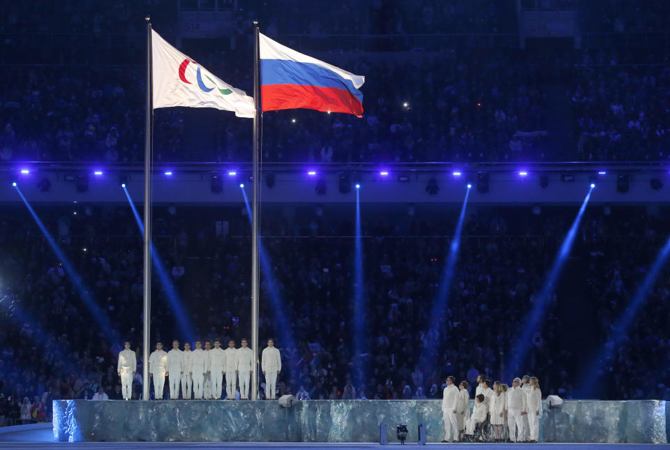 The Paralympic flag (L), is seen besides the Russian national flag during the opening ceremony of the 2014 Paralympic Winter Games. (Reuters)