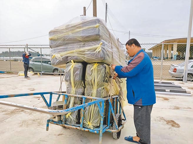 嘉縣蚵農騎著摩托車，後方拉著一個小拖車來載新型環保浮具。（張毓翎攝）