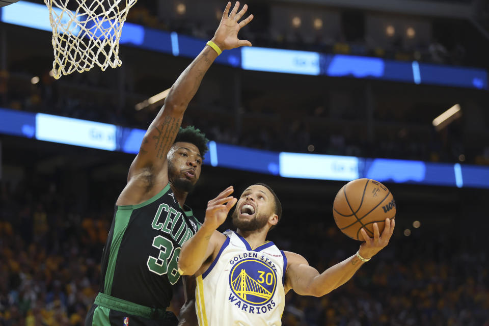Golden State Warriors guard Stephen Curry (30) shoots against Boston Celtics guard Marcus Smart during the second half of Game 5 of basketball's NBA Finals in San Francisco, Monday, June 13, 2022. (AP Photo/Jed Jacobsohn)