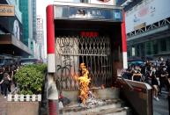 A fire burns at the entrance to an MTR station as anti-government demonstrators attend a protest march in Hong Kong