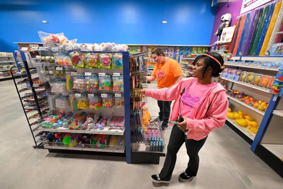 Los empleados de la tienda Daniel Weiss, a la izquierda, y MaKayla Nevins se aseguran de que el inventario esté en orden en la nueva tienda de U.S. Toy Co.