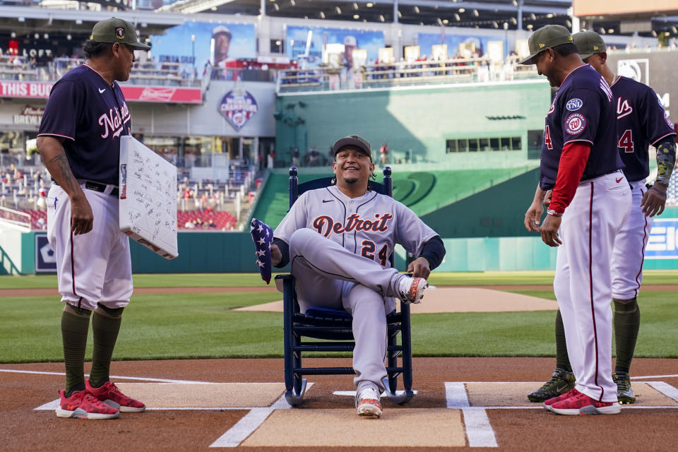 Detroit Tigers' Miguel Cabrera sits in a rocking chair given to him by Washington Nationals catching and strategy coach Henry Blanco, left, manager Dave Martinez and Ildemaro Vargas, back right, before a baseball game at Nationals Park, Friday, May 19, 2023, in Washington. (AP Photo/Alex Brandon)